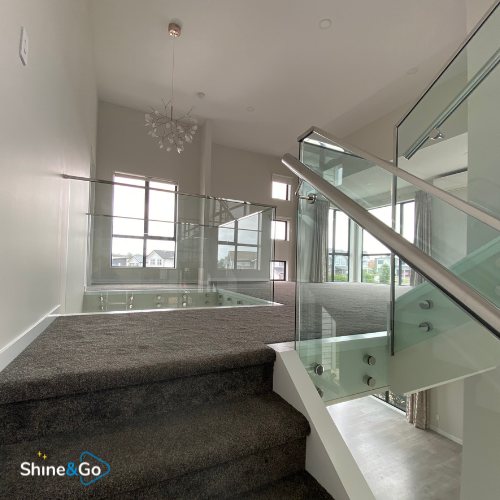 Stairwell landing with glass balustrade and chandelier, cleaned by Shine&Go NZ