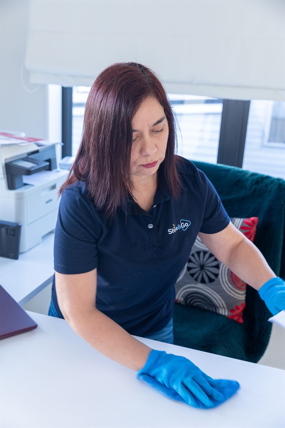 Elba wiping down a desk during a commercial office clean
